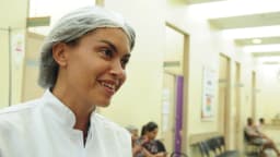 Técnica de enfermagem sorri em corredor de hospital público, foto de arquivo ilustrativa