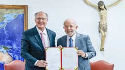 Geraldo Alckmin e Luiz Inácio Lula da Silva lado a lado seguram documento assinado em gabinete, foto de julho de 2024