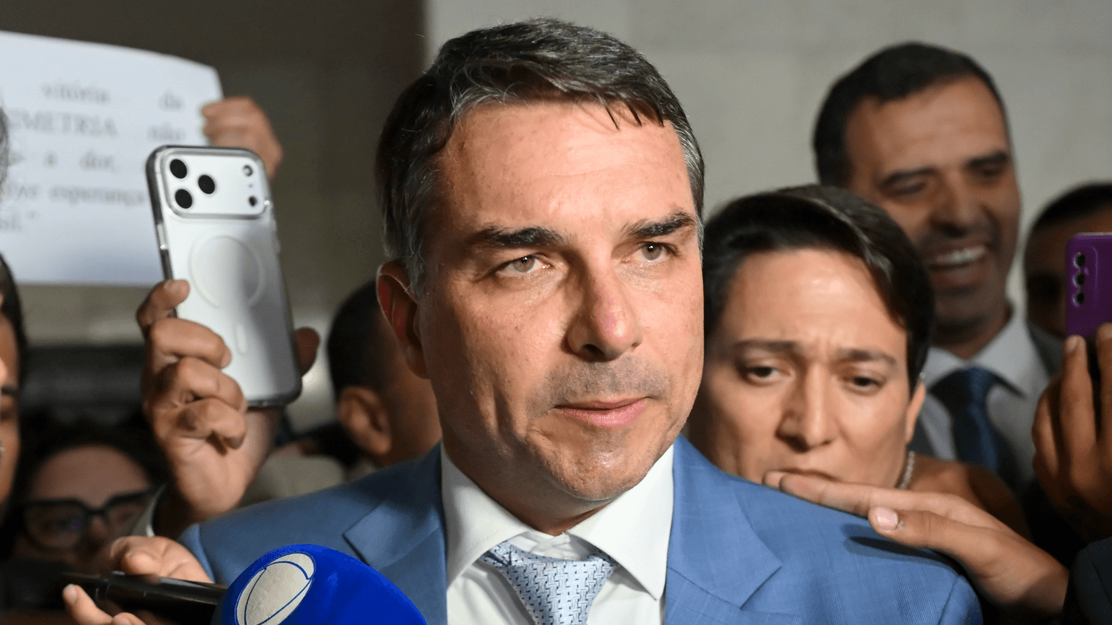 Senador Flávio Bolsonaro concede entrevista a jornalistas, cercado de microfones (foto de arquivo)
