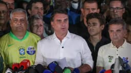 Flávio Bolsonaro discursa em coletiva de imprensa cercado por apoiadores