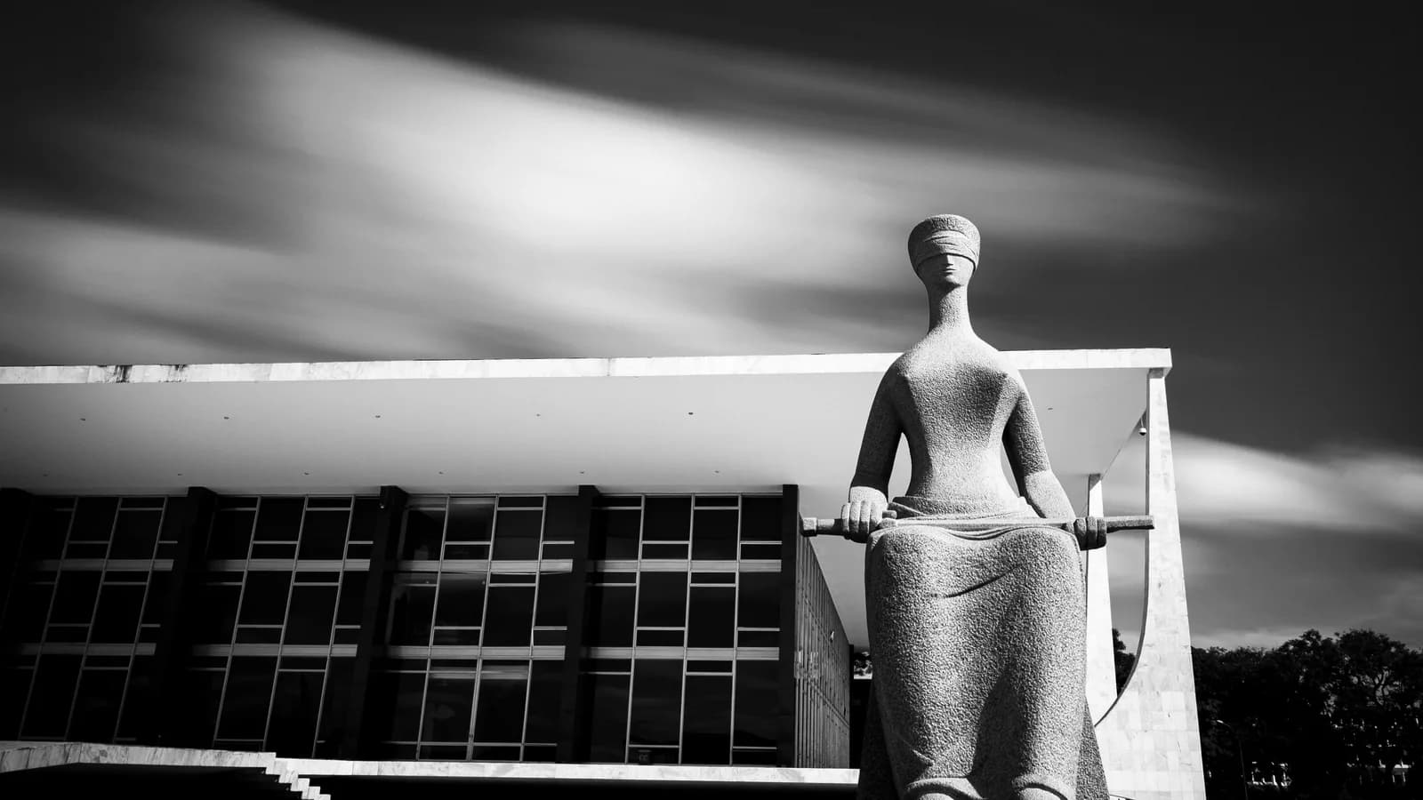 Estátua da Justiça em frente à fachada do Supremo Tribunal Federal, em Brasília, à noite