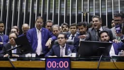 Deputado Hugo Motta cercado por parlamentares na mesa diretora da Câmara dos Deputados