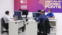 Agentes da Polícia Federal trabalham em computadores durante inspeção de código-fonte