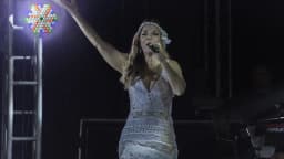Ivete Sangalo canta em show, com braço erguido em direção ao público
