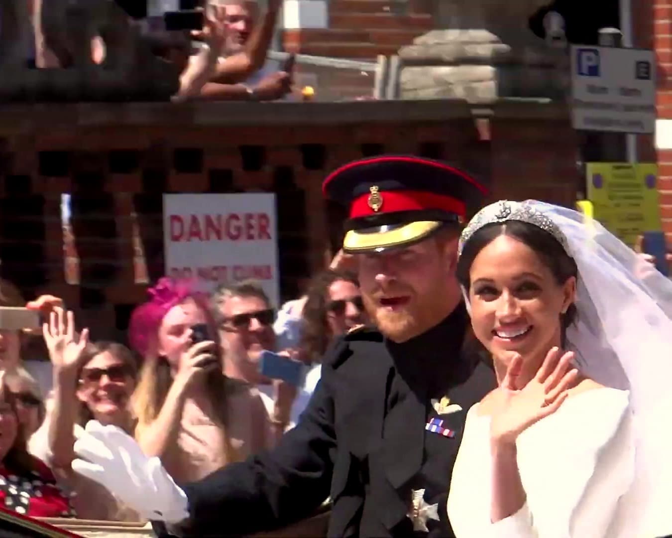 Príncipe Harry e Meghan Markle acenando para o público durante o cortejo de casamento em Windsor, em 2018