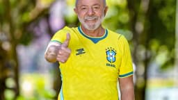 Presidente Luiz Inácio Lula da Silva sorri usando camisa da Seleção Brasileira ao ar livre