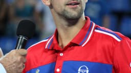 Novak Djokovic com microfone durante entrevista em quadra de tênis