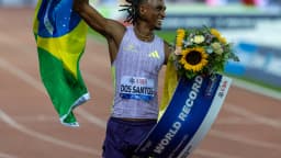 Alison dos Santos comemora com bandeira do Brasil e placa de recorde mundial em Zurique