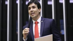 Euclydes Pettersen discursa em plenário da Câmara dos Deputados, de terno escuro e gravata vermelha