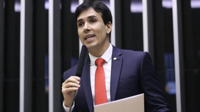 Euclydes Pettersen discursa em plenário da Câmara dos Deputados, de terno escuro e gravata vermelha