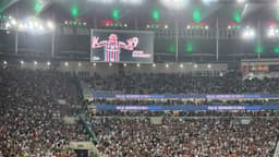 Torcida do Fluminense no Maracanã lotado com imagem de John Kennedy exibida no telão do estádio