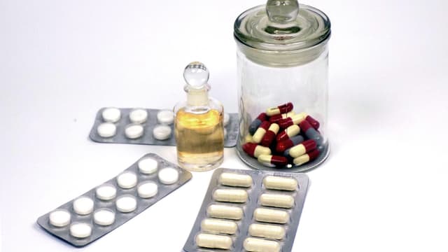Comprimidos e cápsulas em cartelas e frasco de vidro, imagem ilustrativa de medicamentos