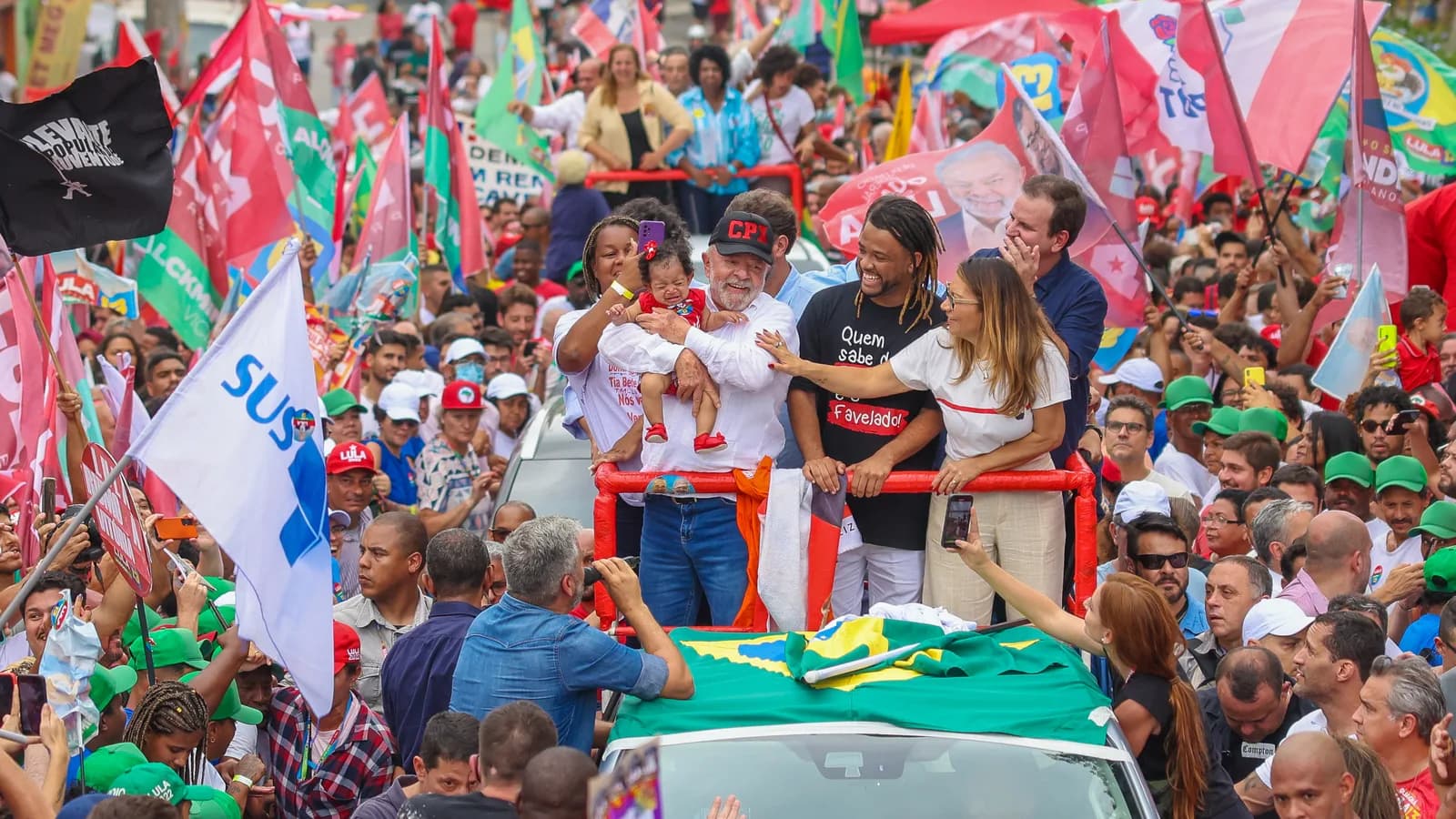 Lula em caminhada de campanha em meio a multidão com bandeiras, em imagem de arquivo de 2022