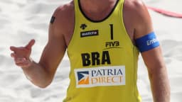 Alison Cerutti, o Mamute, rebate bola durante partida de vôlei de praia com uniforme do Brasil (foto de arquivo)