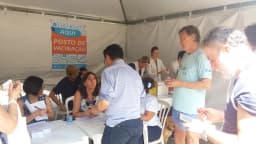 Profissionais de saúde atendem pacientes em tenda de posto de vacinação