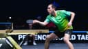 Hugo Calderano em ação durante partida de tênis de mesa, uniforme verde do Brasil