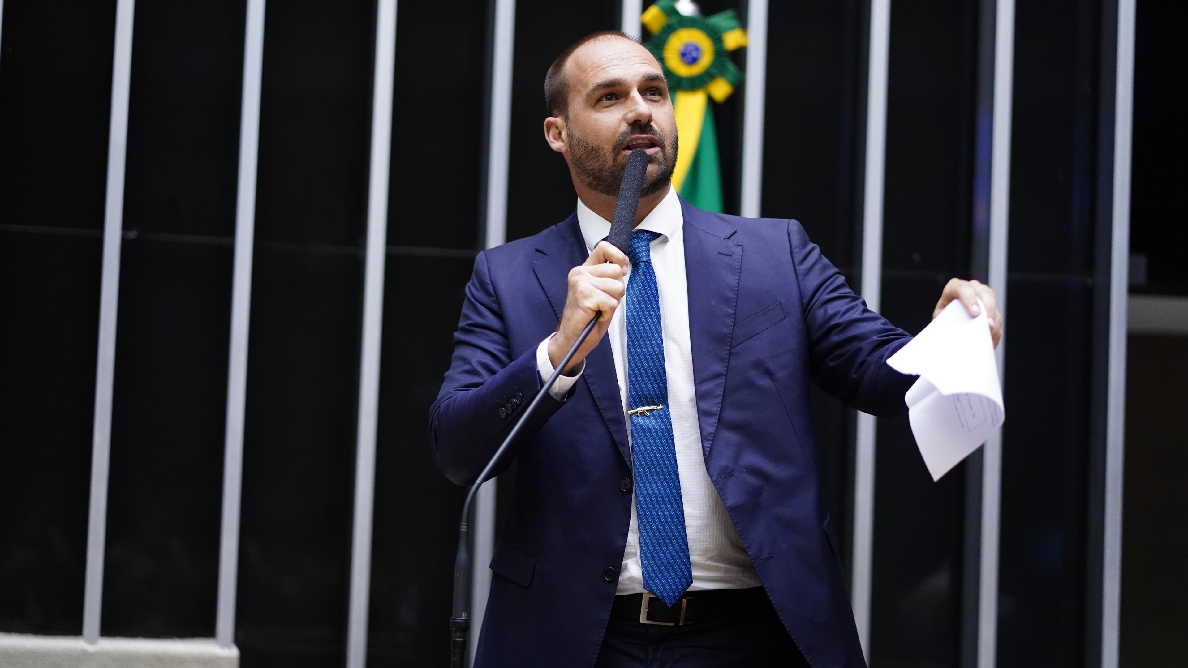 Eduardo Bolsonaro discursa ao microfone segurando um papel durante sessão na Câmara dos Deputados
