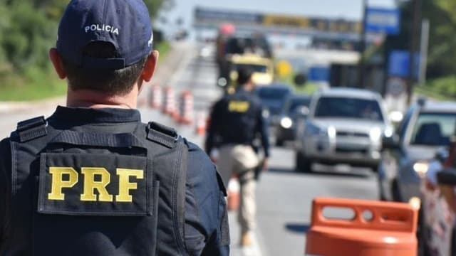 Agente da PRF observa fluxo de veículos em rodovia federal durante fiscalização (foto de arquivo)