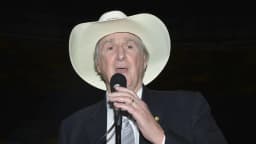 O cantor Sérgio Reis, intérprete de 'O Menino da Porteira', canta ao microfone com chapéu de cowboy
