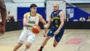 Jogador da seleção brasileira de basquete conduz a bola diante de um marcador da Colômbia