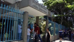 Pessoas entram por portão de escola usada como local de prova (foto de contexto)