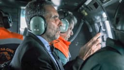 Tarcísio de Freitas dentro de helicóptero, apontando para área sobrevoada