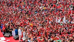 Multidão de apoiadores com bandeiras do Brasil em ato de campanha de Lula