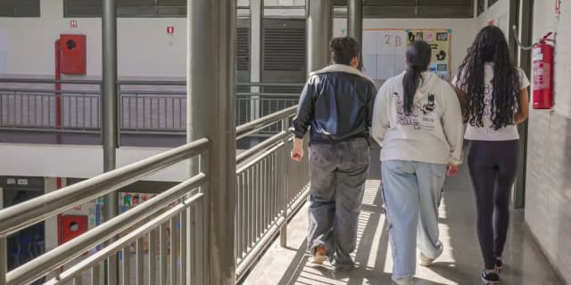 Estudantes caminham pelo corredor de uma escola pública de ensino médio