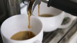 Café especial sendo preparado em cafeteria, com xícaras em primeiro plano