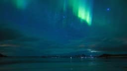 Aurora boreal verde iluminando o céu noturno sobre o lago Mývatn, na Islândia