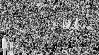 Multidão acompanha o lançamento da campanha de Lula em estádio, com o presidente ao fundo em traje branco