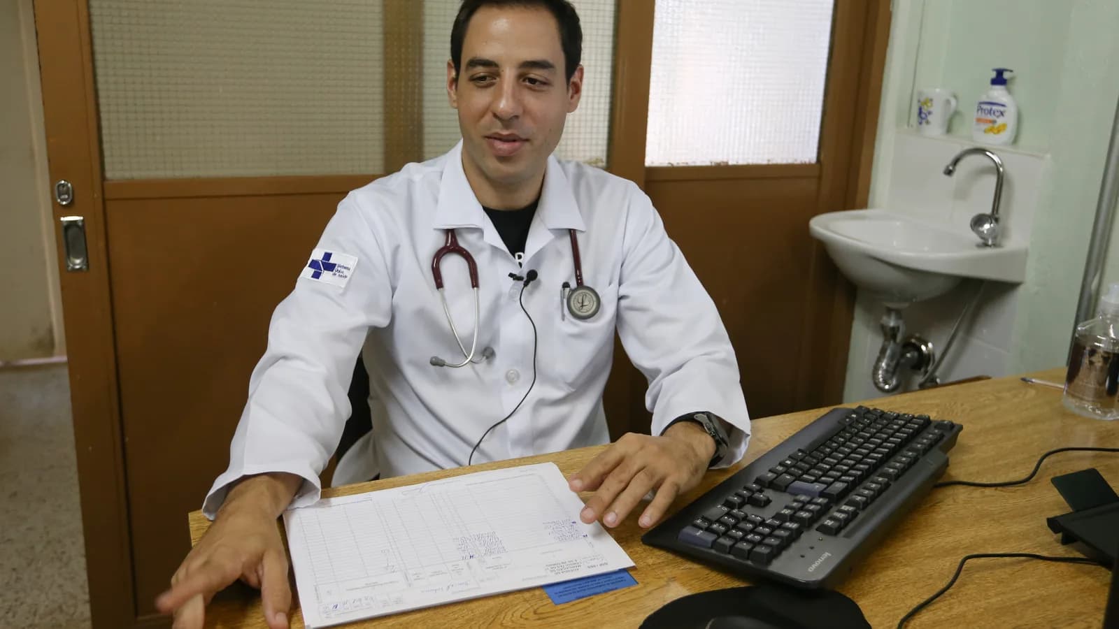 Médico em consultório durante atendimento clínico, foto de contexto ilustrativa