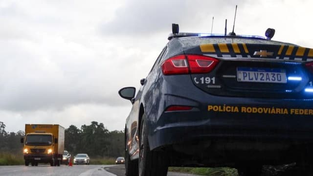 Viatura da Polícia Rodoviária Federal em rodovia, ao lado de caminhão, foto de arquivo