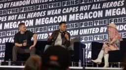 Corbin Bleu e Lucas Grabeel em painel de convenção geek, ambos sentados no palco com microfones