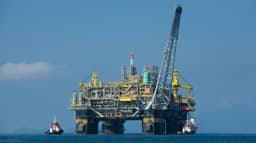 Plataforma marítima da Petrobras no oceano, com rebocadores ao lado; foto de arquivo usada como contexto, não é o poço Sandia-1