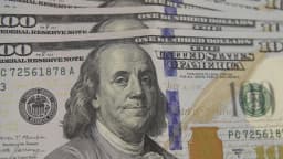 Pessoa conta notas de dólar em casa de câmbio