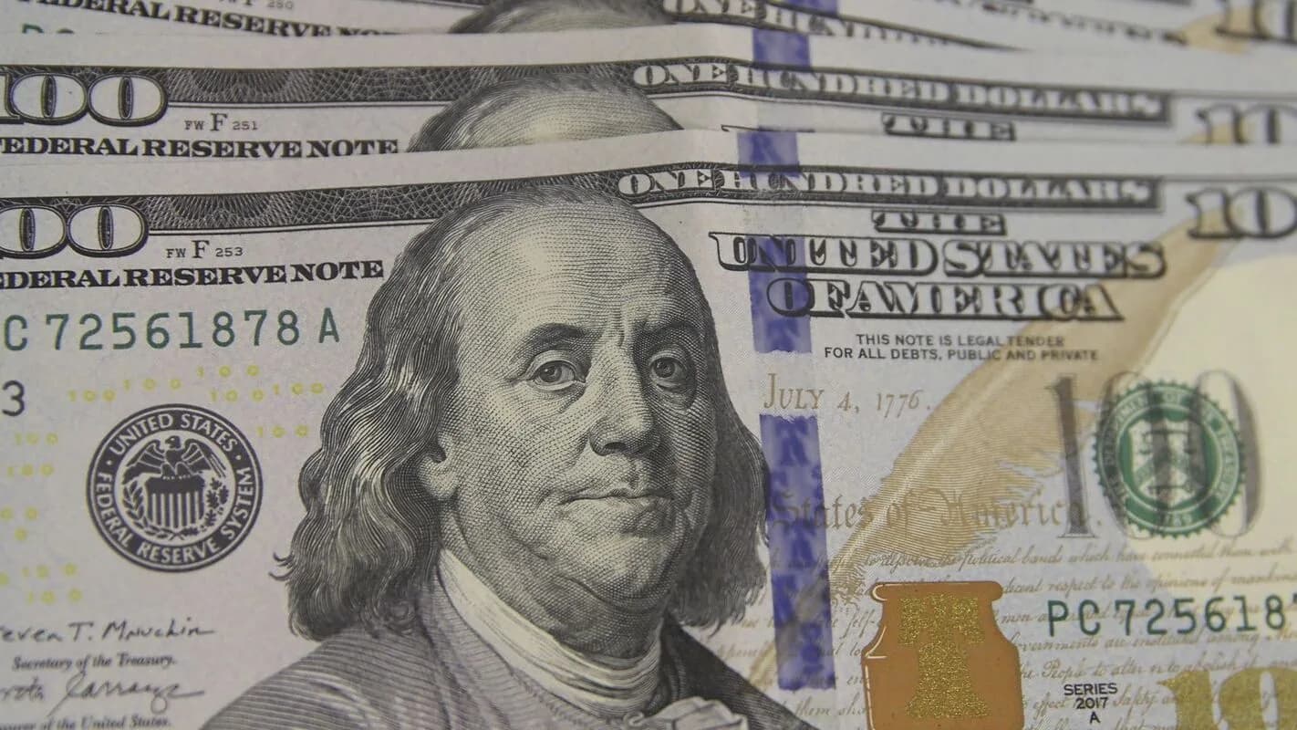 Pessoa conta notas de dólar em casa de câmbio