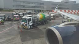 Caminhão abastece avião com querosene de aviação em pátio de aeroporto