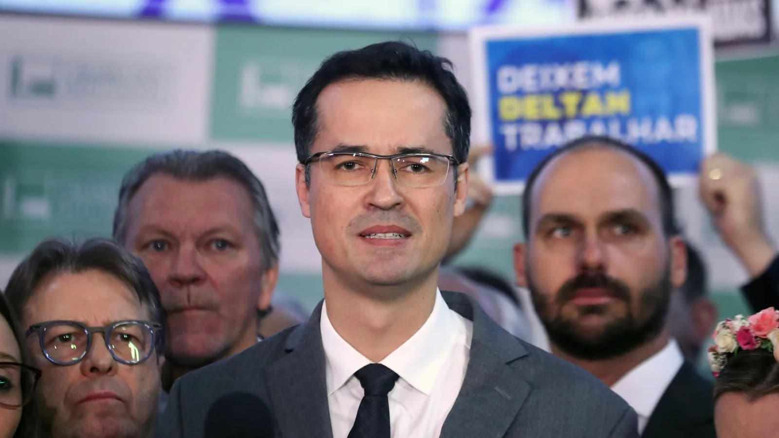 Deltan Dallagnol fala em coletiva de imprensa cercado de apoiadores com cartazes