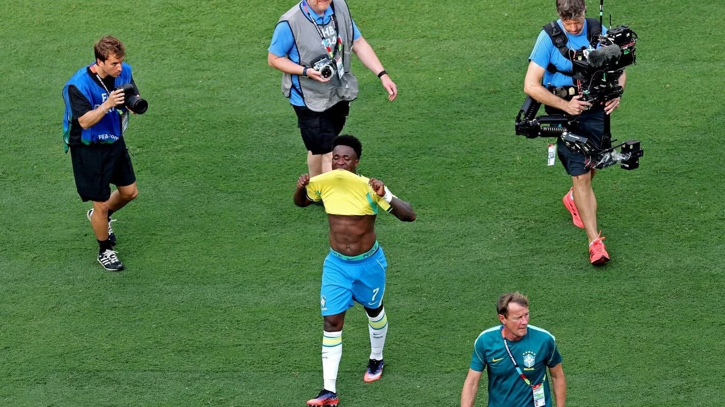 Vini Júnior em campo com a Seleção Brasileira, cercado por fotógrafos