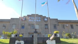 Fachada da sede da Polícia Militar do Espírito Santo, com bandeiras e canhões históricos