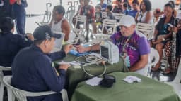 Profissional de saúde realiza exame cardíaco em paciente durante atendimento comunitário