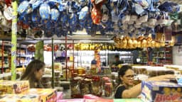 Consumidoras observam produtos em banca de comércio popular no Brasil