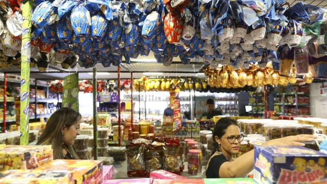 Consumidoras observam produtos em banca de comércio popular no Brasil