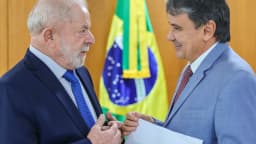Lula conversa com o ministro do Combate à Fome, Wellington Dias, segurando documentos