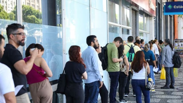 Fila de candidatos aguarda em frente a prédio para prova de concurso público (foto de arquivo, contexto)