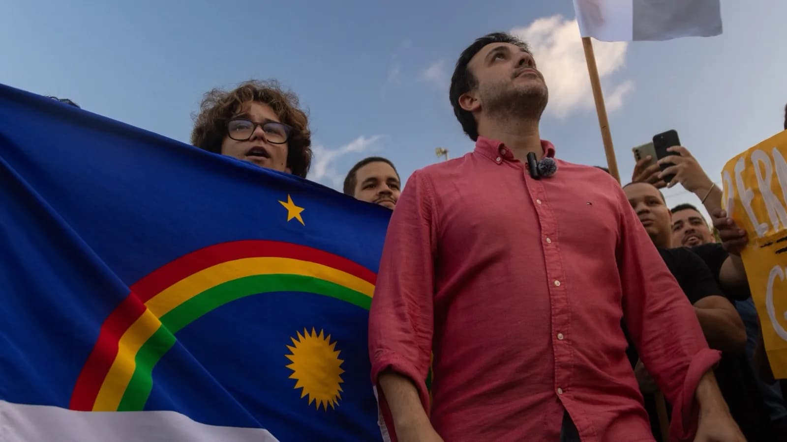 Renan Santos em ato de campanha no Marco Zero, no Recife, ao lado de apoiadores e bandeira de Pernambuco