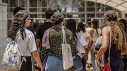 Grupo de candidatos caminha em fila até o local de aplicação de prova de concurso público