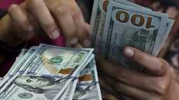 Pessoa contando notas de dólar