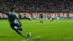 Jogador do Bahia em ação durante partida no estádio do Pituaçu, com torcida ao fundo